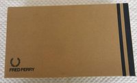 Fred Perry branded cardboard shoe box, brown with black logo and stripes on top