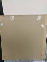 Back of item covered with cardboard and taped for shipping protection