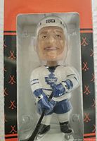 Front view of the sealed bobblehead in box showing Tie Domi in Toronto Maple Leafs uniform, clear plastic window shows the figurine in detail.