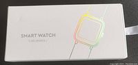 White box with holographic outline of a smartwatch and the text "SMART WATCH DO SPORTS" on the top.