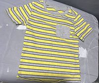 Full view of toddler t-shirt showing yellow and gray stripes with gray pocket detail