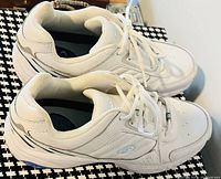 Side view of the ladies white running shoes showing overall design and condition.