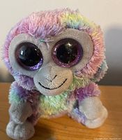 Multicolored pastel Beanie Boos monkey plush with large purple glitter eyes