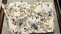 Front view of off-white bustier with brown and black floral pattern, structured cups visible.