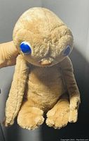 Frontal image showing the entire plush with focus on the large shiny blue eyes and full body.