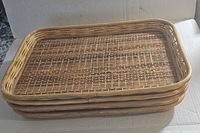 Stack of four rectangular bamboo wicker rattan trays showing side profile, highlighting thickness and woven design.
