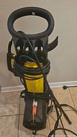 Full view of Karcher 395 pressure washer upright with power cord wrapped around unit.