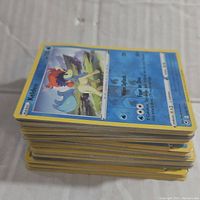 Stack of assorted Pokemon cards viewed from the side showing the card edges and top card Keldeo