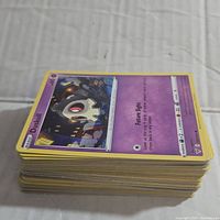 Stack of assorted Pokemon cards showing card with Duskull on top.