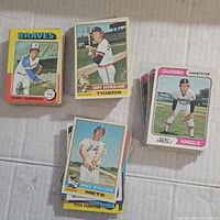 Initial overview photo showing multiple stacks of vintage baseball cards from teams including Braves, Tigers, Angels, and Mets.