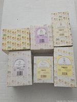 Top view of six original boxes of Precious Moments figurines showing vintage designs and labels.