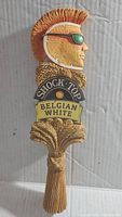 Front view of Shock Top Belgian White beer tap handle showing detailed profile with orange slice face, sunglasses, and wheat sheaf design