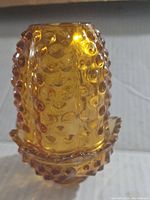 Side view showing amber hobnail textured glass fairy lamp shade and base.
