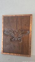 Front view of the wooden plaque showing the full carved eagle and copper border.