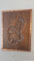 Full view of wooden eagle plaque with copper border, showing carved eagle and overall piece condition.