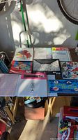 Photo of various arts and crafts pads and kits arranged on the floor including watercolor paper pads, origami paper, puzzle, and sketchbook.