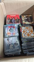 Open box showing various music CDs inside including Weezer and others