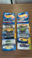 Photo showing all 10 Hot Wheels cars in original packaging arranged on a table.