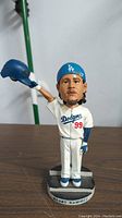 Front view of Manny Ramirez bobblehead in Dodgers uniform holding cap in right hand, standing on base with name label.