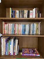 Books arranged on wooden shelves; mixed fiction, self-help books