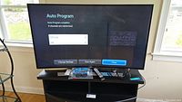 Samsung 66 inch curved TV showing Auto Program screen with tuning results and scan options.