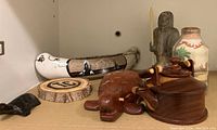 Soapstone figurine, painted canoe, wooden teapot and turtle puzzle, sand art jar, wood slice with initials