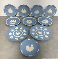 Overview of all 10 Wedgwood collector plates showing various architectural and Christmas relief designs on blue jasperware backgrounds