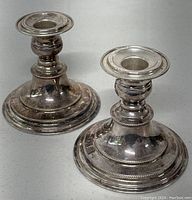 Pair of vintage English electroplated on copper candle holders, showing round bases with beaded accents and turned columns, minor surface wear visible.