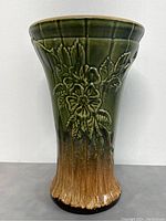 Front view showing embossed floral design and green to brown ombre glaze on the antique Roseville vase.