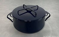Blue Dansk Kobenstyle casserole with lid shown from front angle on gray surface.