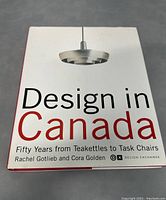 Front cover of 'Design in Canada: Fifty Years from Teakettles to Task Chairs' hardcover book showing title, authors, and a hanging light fixture image.