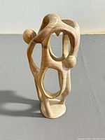 Photo front view of signed Kenyan soapstone 'Circle of Friends' figure showing three interconnected human forms, smooth natural stone finish.