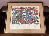 Close-up of framed print showing detailed imagery of horse, bird, and flowers, with visible paper texture and artist's stamp or signature.
