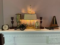 Wide view of assorted decorative items on white fireplace mantel showing overall arrangement and condition.