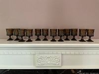 Set of 12 amber retro glass goblets arranged in a row showing overall quantity and style.