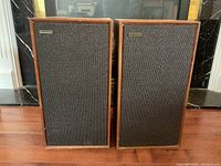 Front view of two Celestion speakers side by side with dark speaker grilles and wooden cabinets
