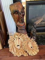 Front view showing all four masks and sculptures together on floor