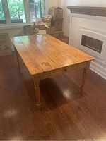 Full view of pine harvest table showing plank top and turned legs