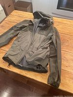 Jacket laid flat on wooden surface showing overall condition and color.