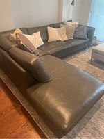 Angle view of left chaise and sofa section showing overall shape, chaise length and width, leather color