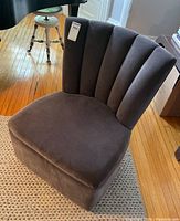 Front angled view showing scalloped channel-tufted curved back and seat