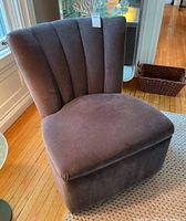 Front and angled view showing channel tufted backrest and velveteen fabric upholstery in dark brown-gray.