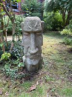 Front view of concrete Moai head sculpture on garden lawn