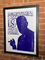 Overall view of the framed Freud poster showing the blue silhouette and text on a brick background.