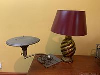 Photo showing both lamps, including twisted brass base lamp with purple shade and adjacent saucer shade lamp.
