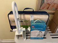 Photo showing the Tempur-Pedic pillow in original packaging, Life Thera-Bag Comfort Wrap box, and white removable bath tub hand rail.