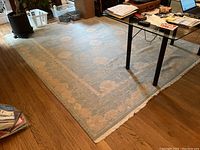 Full view of rug under glass-top table on hardwood floor