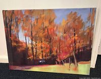Frontal view of oil painting showing autumn forest with orange and yellow trees, red ground, small car at edge