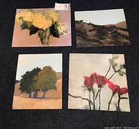 Set of four original art paintings on board, including floral and landscape subjects, arranged on a dark surface for display.