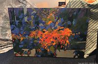 Full view of abstract oil painting on canvas displaying vibrant foliage-like orange and blue brushstrokes.